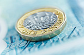 Close up one pound coin on five pound note