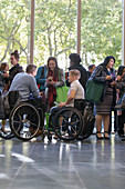 Business people in wheelchairs talking at conference