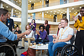 Colleagues clapping for speaker in wheelchair