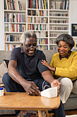 Senior couple checking blood pressure in living room