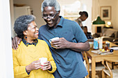 Happy, affectionate senior couple drinking coffee