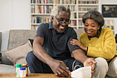 Smiling senior couple checking blood pressure