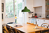 Green pendant light hanging over dining table