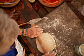 Overhead view senior woman rolling pizza dough