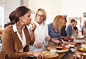 Senior woman and chef tasting cheese