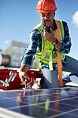 Male engineer with walkie-talkie repairing solar panel