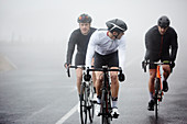 Dedicated male cyclists cycling on rainy road