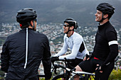 Male cyclist friends taking a break, talking