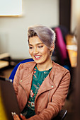 Smiling creative businesswoman using digital tablet