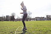 Woman practicing speed ladder drill in sunny park