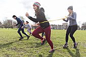 Women exercising, doing team building exercise in park