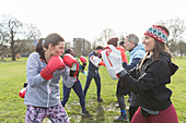People boxing in sunny park