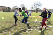 People racing, doing team building exercise in sunny park