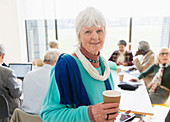 Businesswoman drinking coffee in meeting
