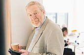 Portrait confident senior businessman with digital tablet