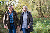 Happy mature couple walking in autumn park