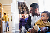 Father putting shoes on baby son on stairs