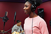 Smiling teenage girl musician recording music