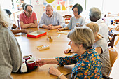 Senior friends playing games and drinking tea
