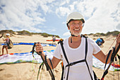 Mature male paraglider on beach with equipment