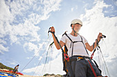 Mature male paraglider preparing equipment