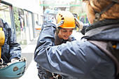 Woman helping friend with zip line helmet