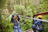 Woman zip lining above trees