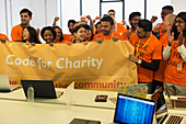 Hackers with banner cheering, coding at hackathon