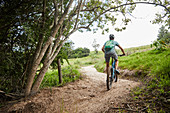 Man mountain biking on rural trail