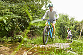 Man mountain biking on muddy trail