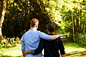 Affectionate male gay couple hugging, walking