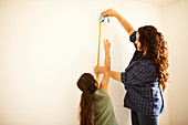 Mother and daughter measuring wall for project