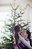 Affectionate mother and daughter looking up tree