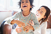 Playful mother and daughter laughing