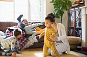 Young family in pyjamas playing in living room