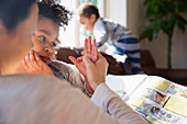 Mother and daughter holding hands, reading book