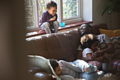 Happy father and children cuddling on sofa