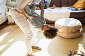 Playful mother and daughter in living room