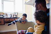 Playful, innocent boy climbing on furniture