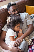 Father cuddling with toddler daughter