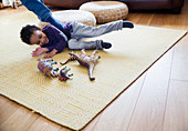 Playful boy with dinosaur toys on floor
