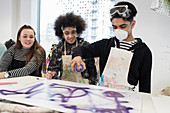 Teenagers spray painting in art class