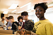 Portrait teenage girl enjoying pizza with friends