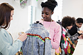 Teenage girls designing denim jacket