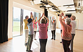 Active seniors stretching arms overhead in circle