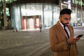 Businessman texting corner at night