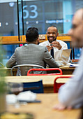 Businessmen talking, working in cafe