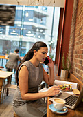 Businesswoman, working at laptop in cafe