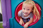 Portrait cute, girl playing in tube slide