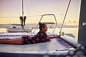 Serene young woman relaxing on catamaran net